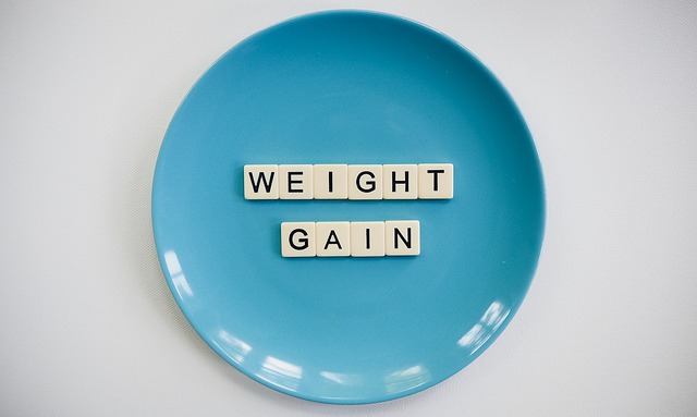 a bright blue plate with the words weight gain spelled on it in Scrabble tiles