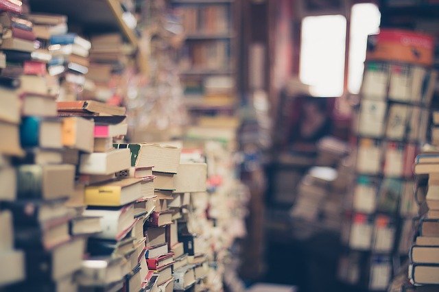 stacks and rack of novels in a used bookstore